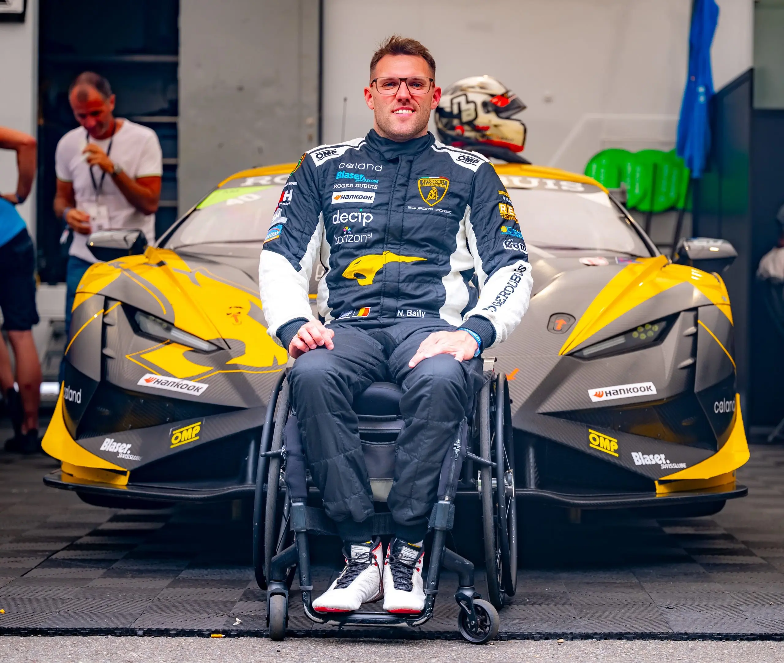 Niguel Bailly souriant devant son véhicule de course